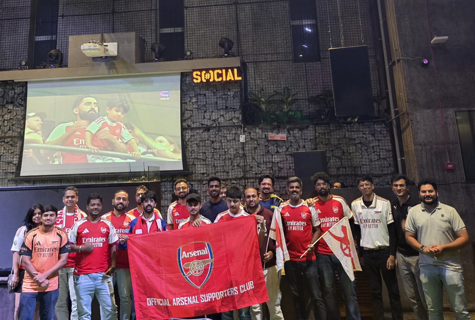 Arsenal Pune SC supporters with the club banner after the 2026 Community Shield screening at AntiSocial in Pune